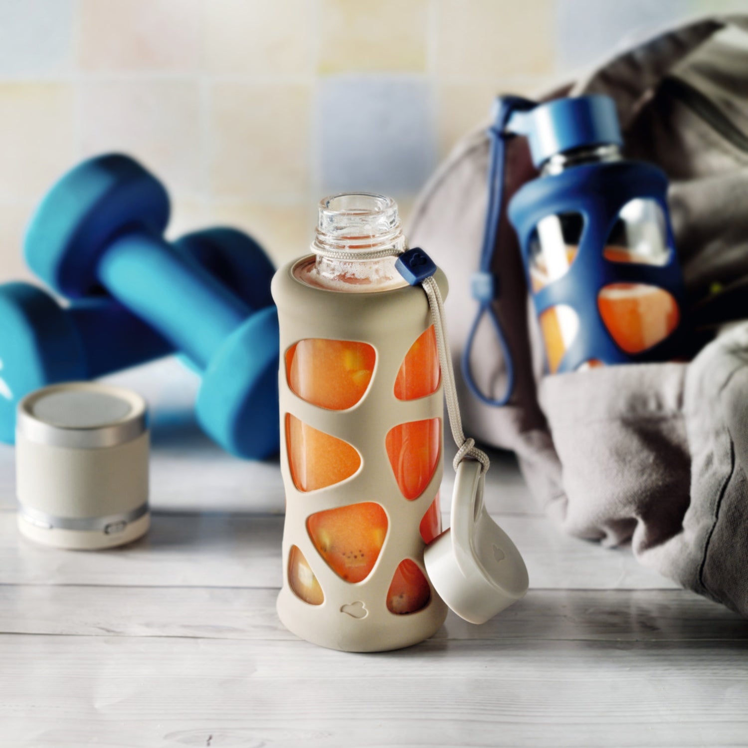 Kleine Glasflasche mit helloranger Füllung und beiger Hülle, im Fitnesskontext