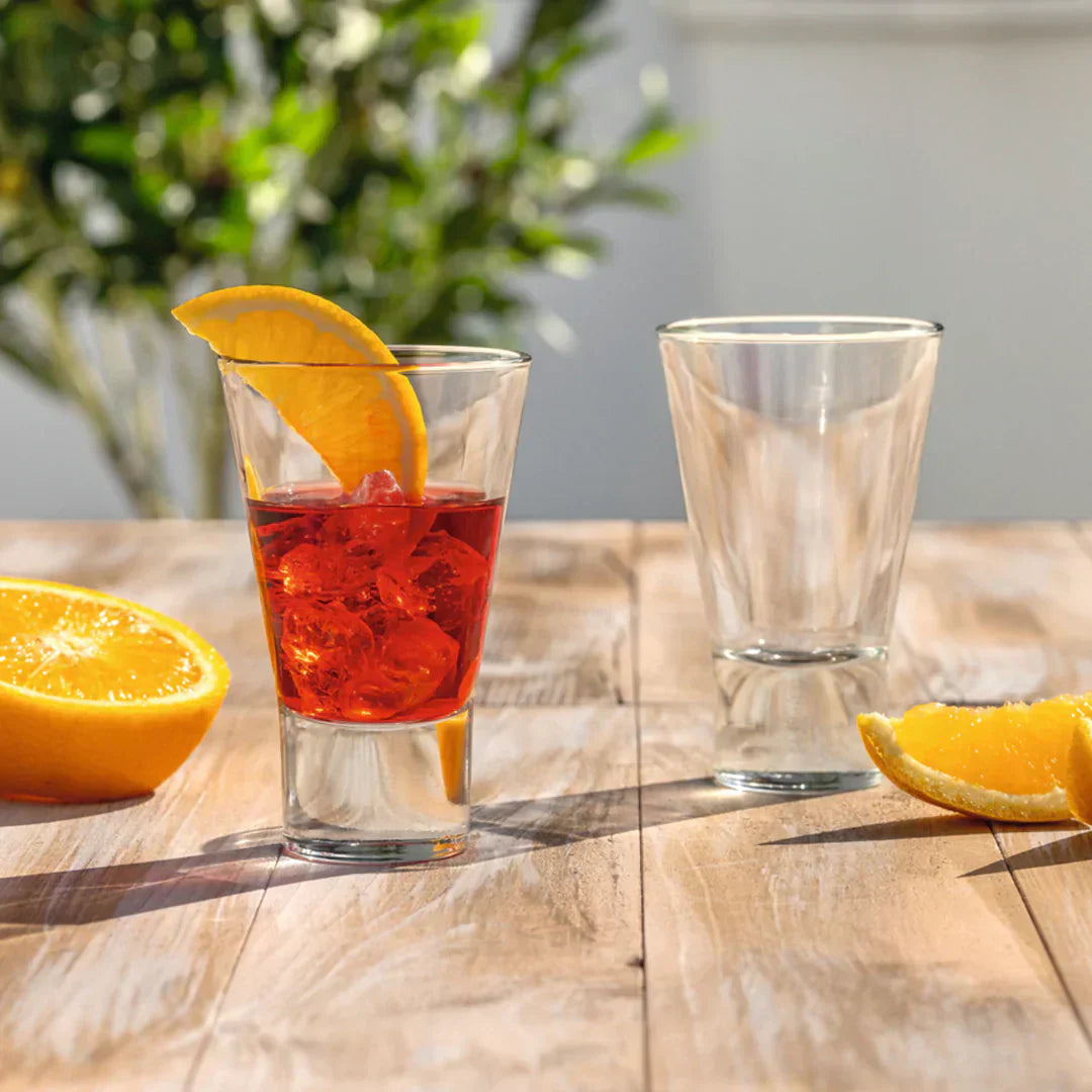 Zwei kleine LEONARDO Gläser mit Aperitif und Orangenscheibe auf rustikalem Tisch.