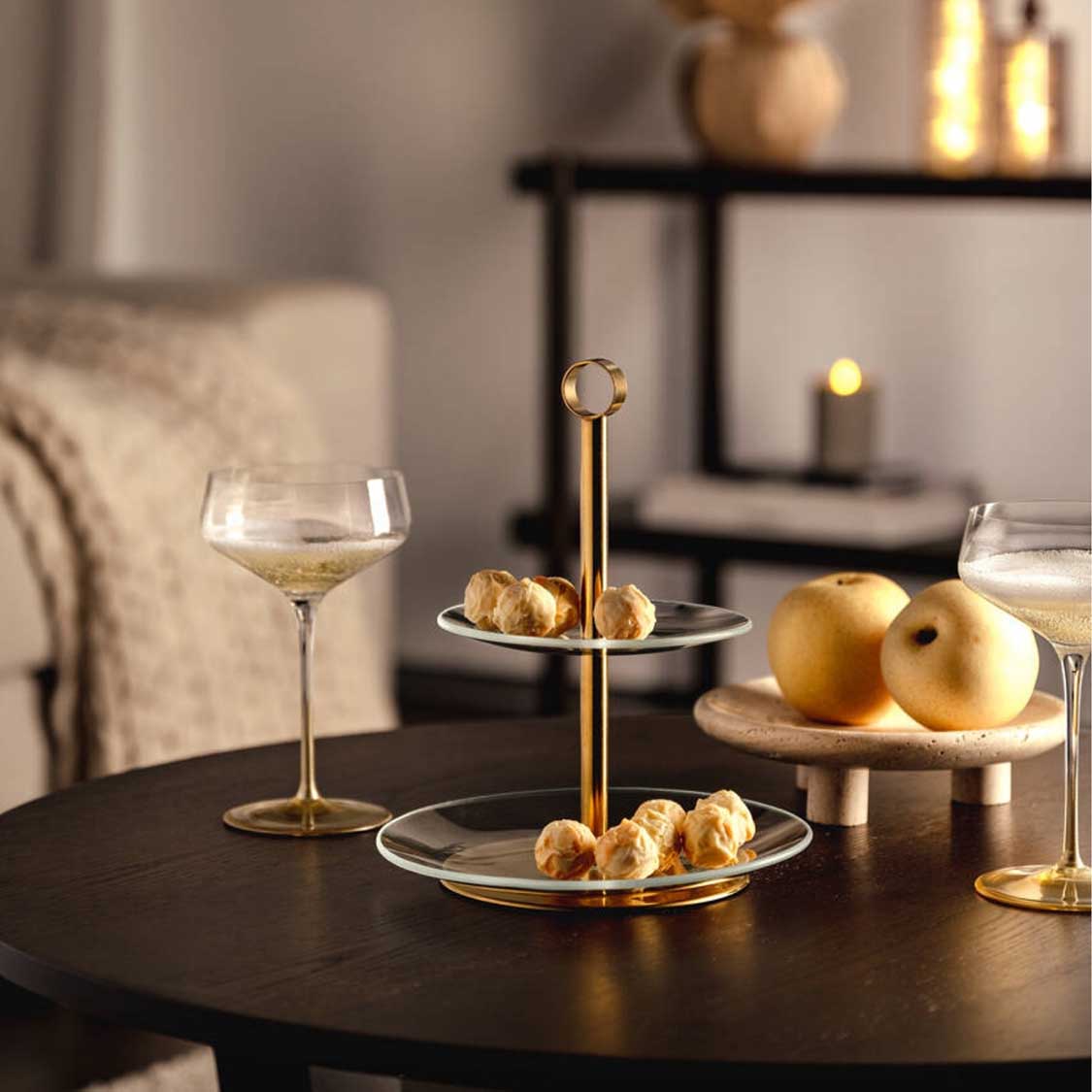 Champagnerschale PUCCINI gold mit Wein, auf schwarzem Tisch mit Gebäck und Äpfeln