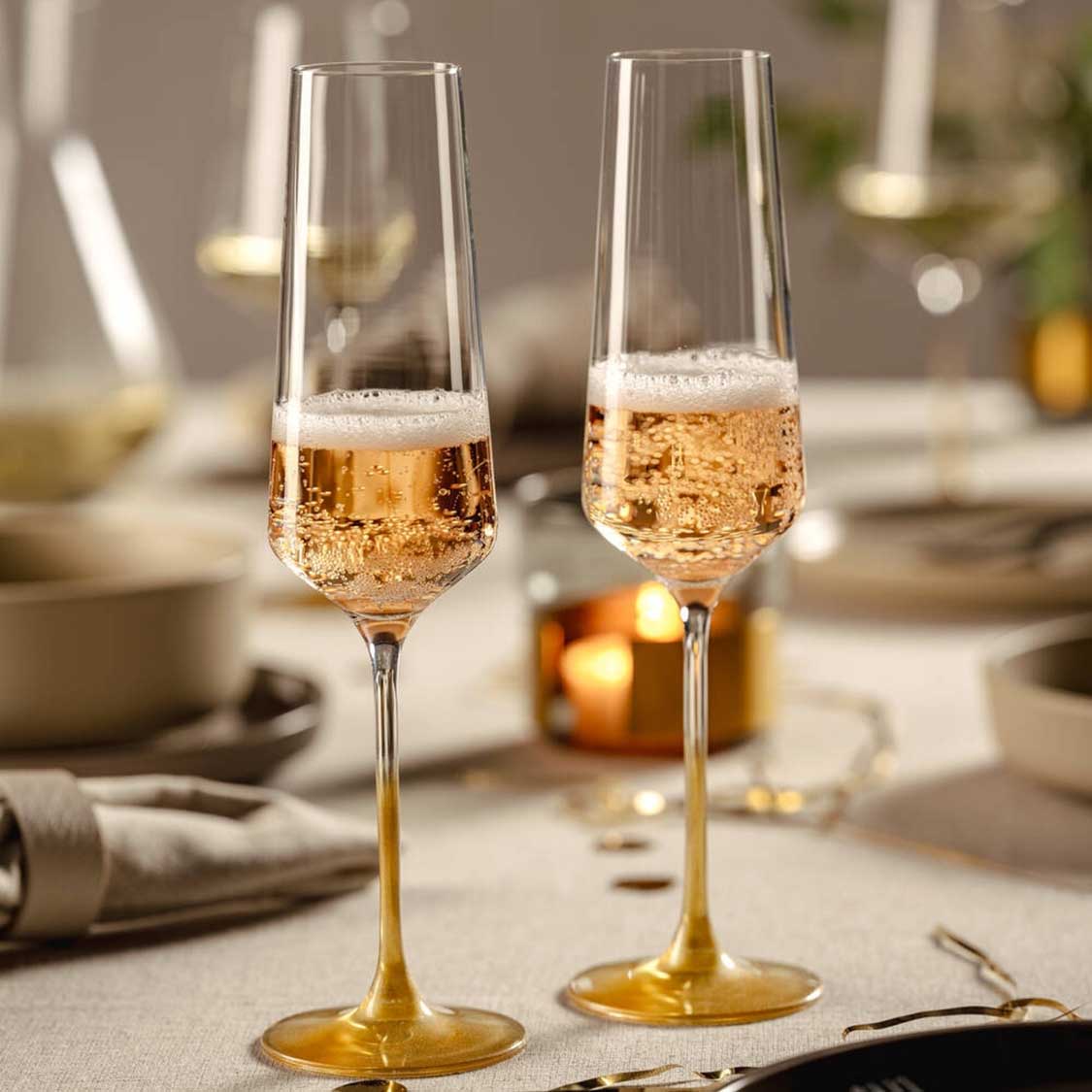 Zwei Sektgläser PUCCINI mit Champagner auf gedecktem Tisch