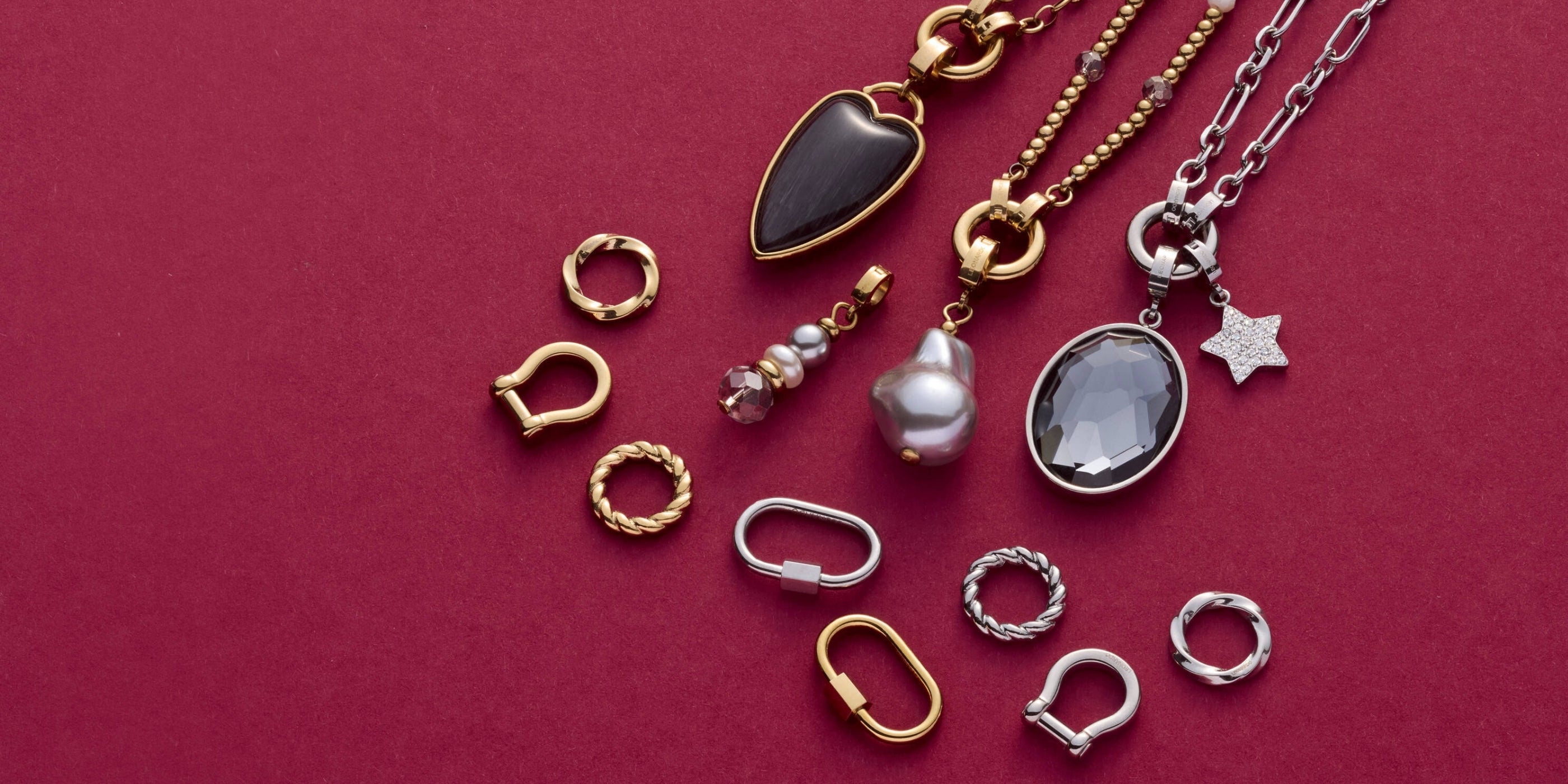 Detailreiche Anordnung von Ketten, Anhängern und Verbindern in Gold und Silber, kreativ präsentiert.