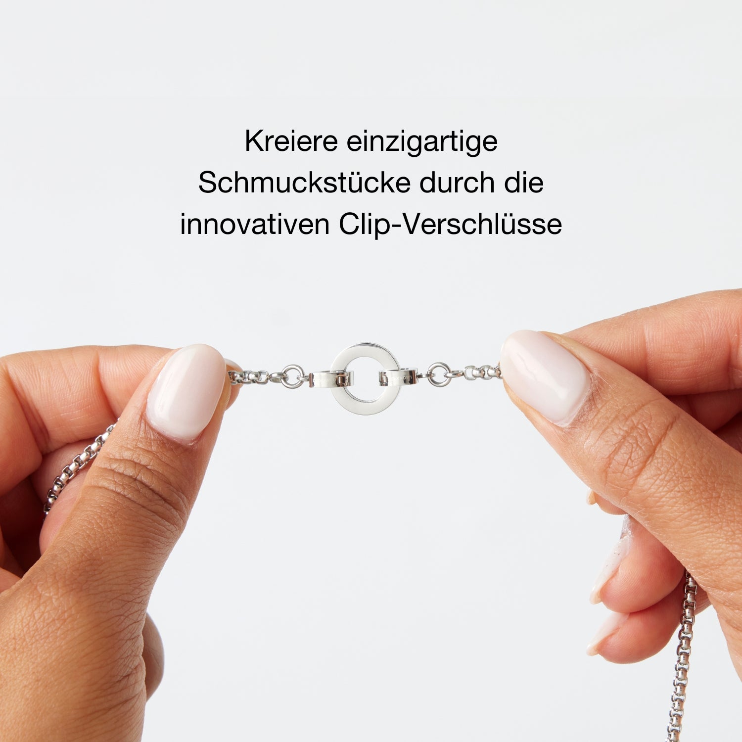 Zwei Hände halten ein Schmuckstück mit innovativem Clip-Verschluss in der Mitte, darüber der Text: „Kreiere einzigartige Schmuckstücke durch die innovativen Clip-Verschlüsse“.