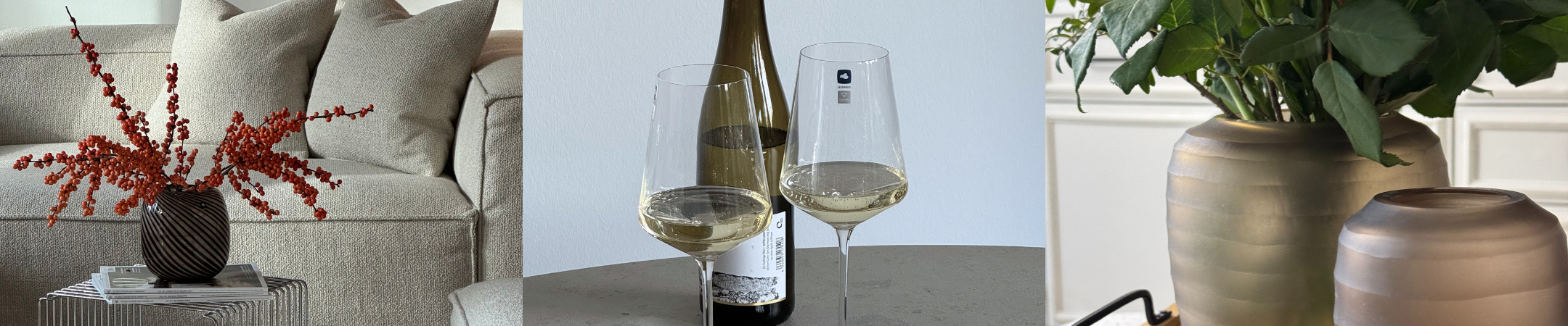Breites Banner mit Wohnaccessoires: Vase mit roten Beeren auf Beistelltisch, zwei Weißweingläser mit Flasche und dekorative Vasen mit Pflanze.
