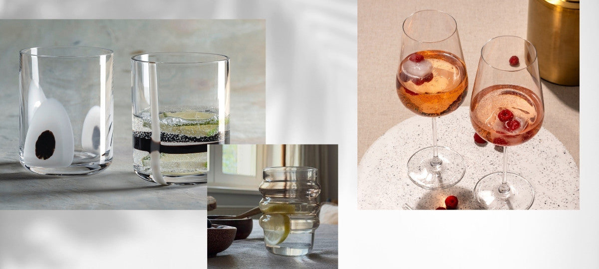 Trinkgläser mit Mustern, Zitronenwasser und zwei Rosé-Getränken mit Beeren auf hellem Tisch.