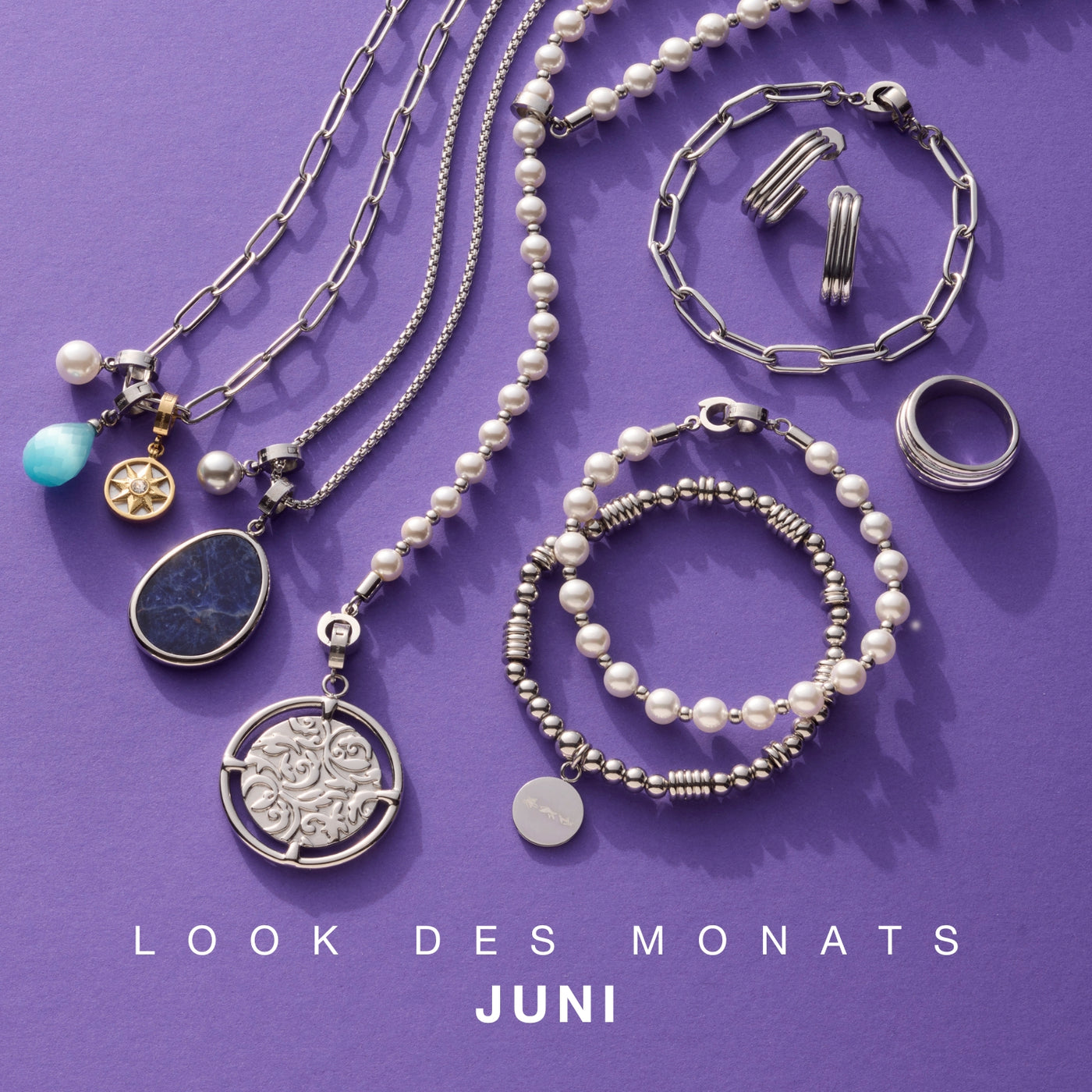 Look des Monats Juni: LEONARDO-Schmuck in Silber mit Perlen, Gliedern und filigranen Anhängern auf violettem Hintergrund