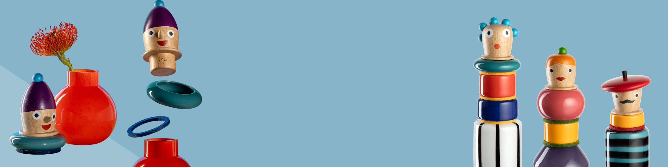 Bunte, modular zusammensetzbare Vasen mit Holzköpfen und fröhlichen Gesichtern. Es gibt austauschbare Elementen, die als dekorative Vasenverschlüsse dienen – farbenfroh inszeniert auf hellblauem Hintergrund.