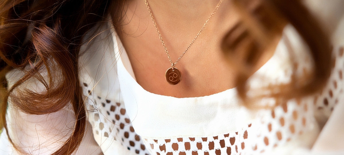Goldene Halskette von LEONARDO mit rundem Anhänger und eingraviertem Krebs-Symbol als filigranes Sternzeichen-Accessoire.