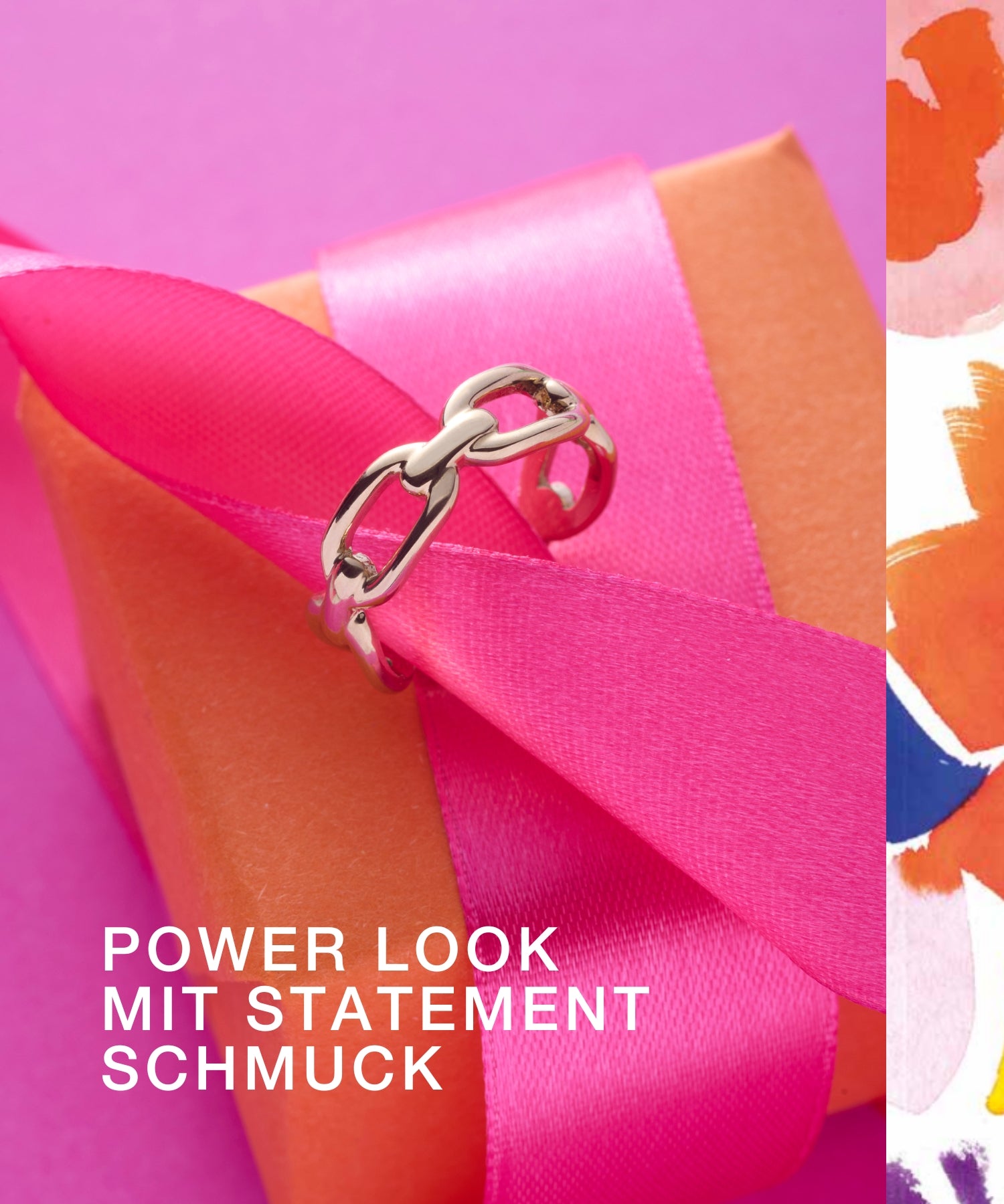 Silberner Statement-Ring auf Geschenkbox mit pinker Schleife und orangem Papier. "Power Look mit Statement Schmuck"