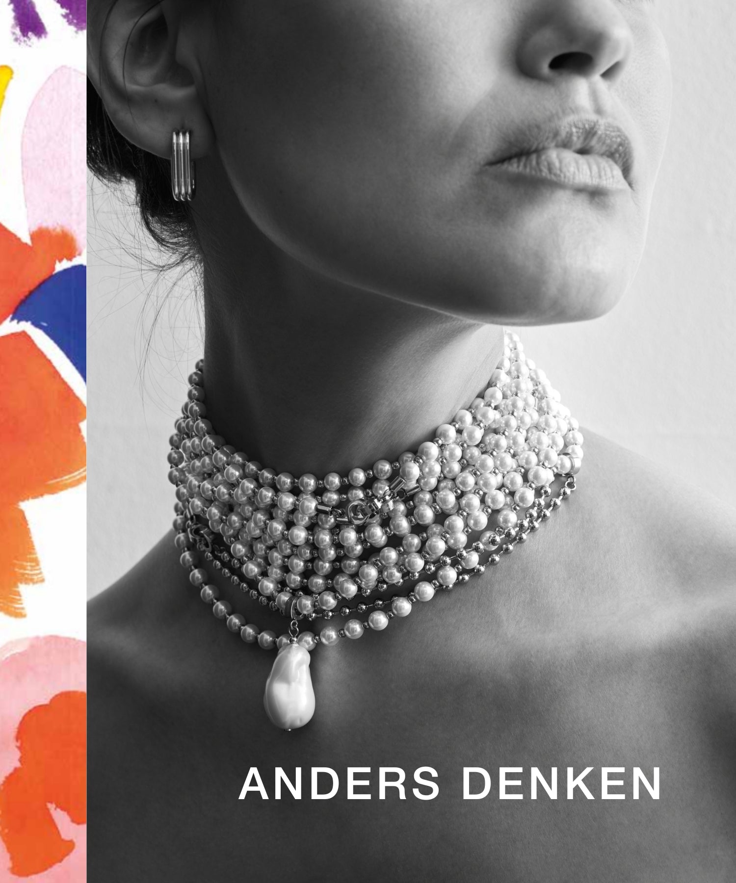 Nahaufnahme einer Frau mit mehreren Lagen an Perlenketten als Statement-Choker und silbernen Creolen vor neutralem Hintergrund. Links ein farbiger Rand mit Pinselstrichmuster, darunter der Schriftzug "ANDERS DENKEN".