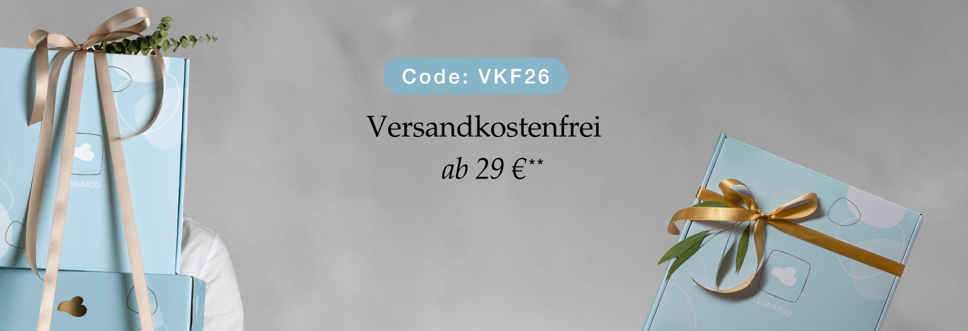 Versandkostenfrei ab 29 €, Code VKF26. Hellblaue Geschenkboxen mit goldenen Schleifen und Gründekor auf grauem Hintergrund