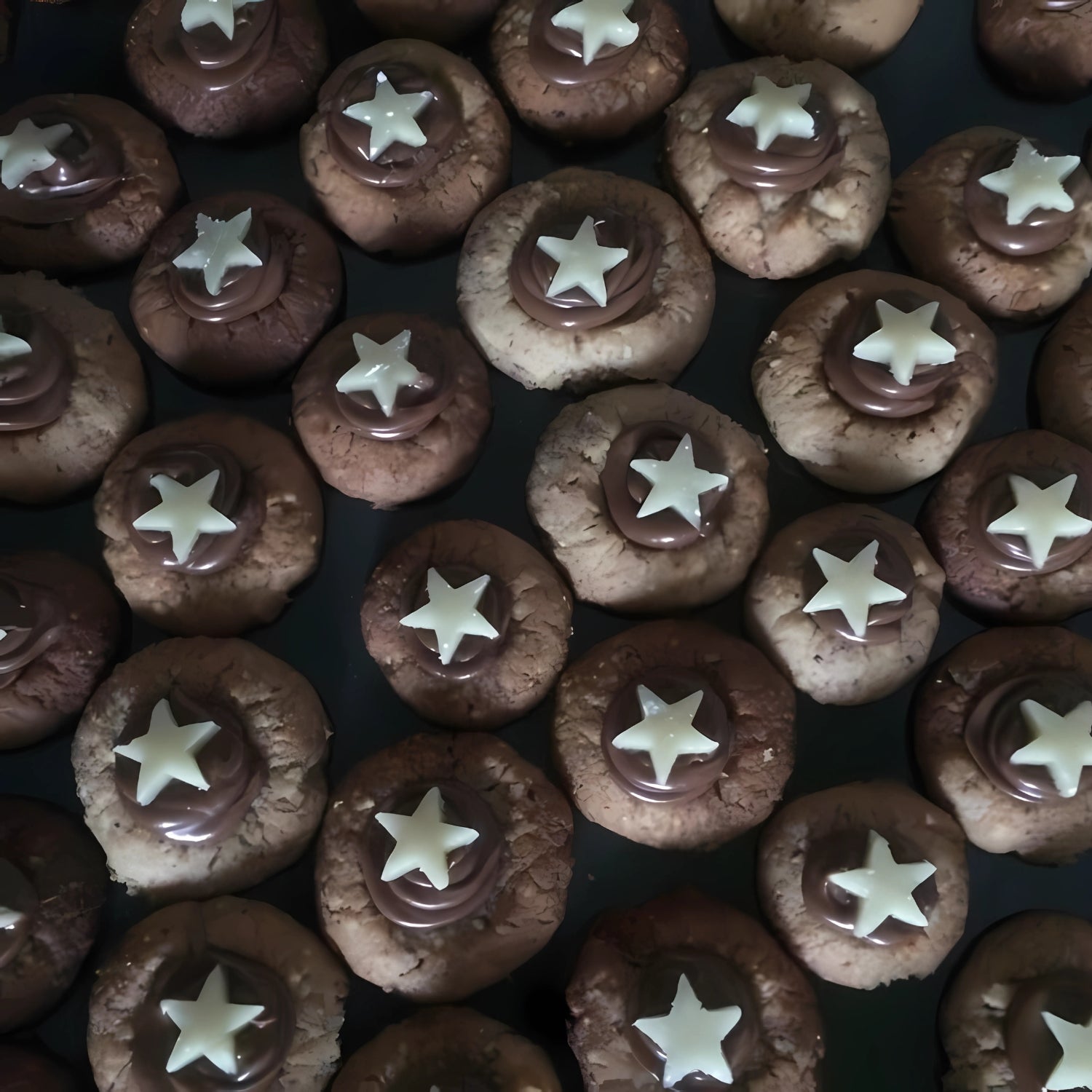 Weihnachtliche Plätzchen mit Schokocreme und weißen Sternen liebevoll dekoriert.