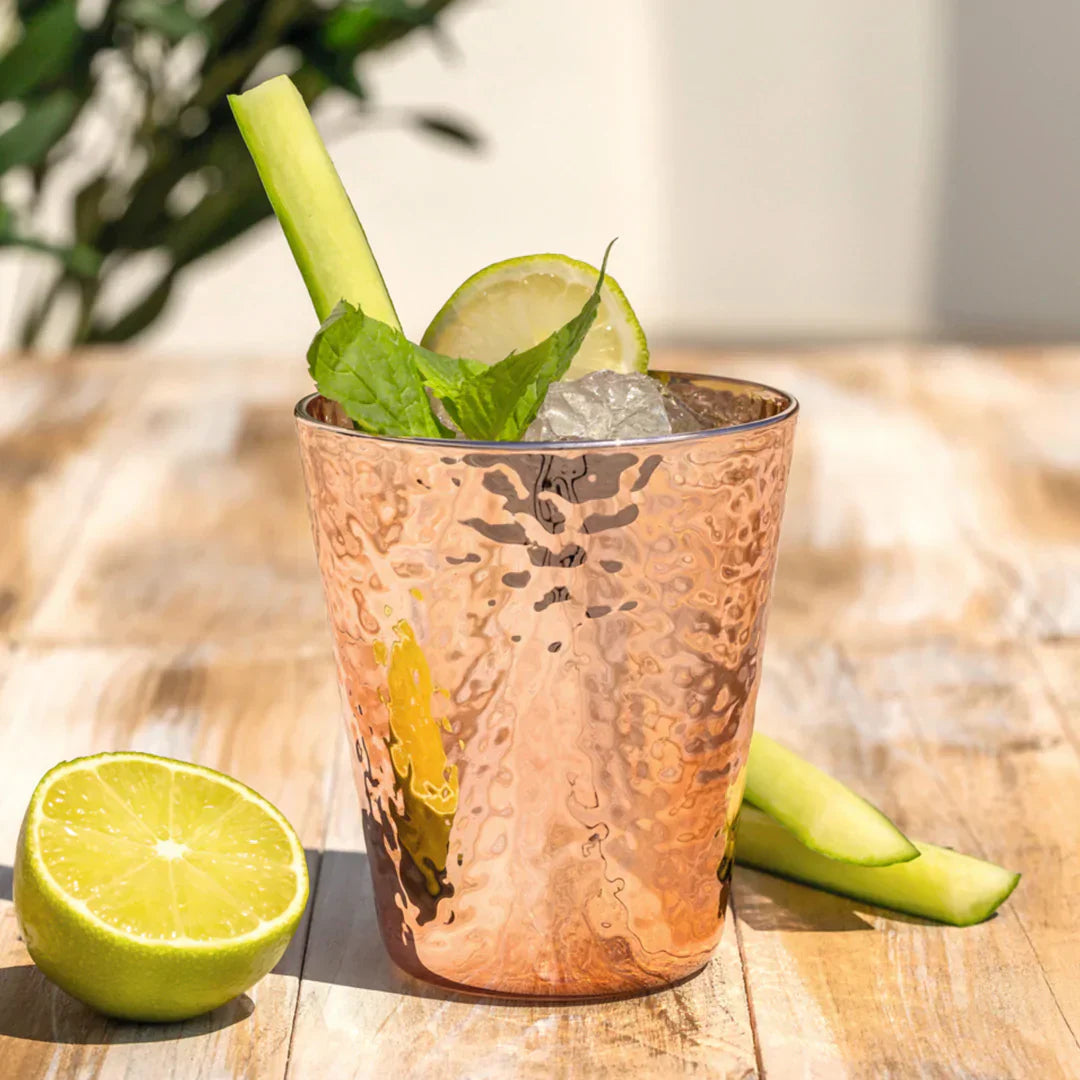 Ein frischer Drink mit Eis, Gurke, Limette und Minze im gehämmerten Kupferbecher.