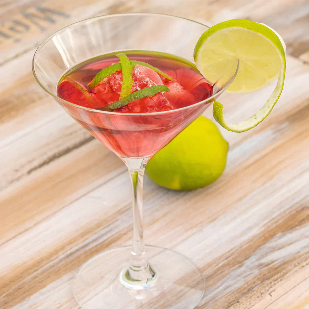 Ein eleganter Cocktail mit Eis, Limettenscheibe und Zeste im Martiniglas serviert.