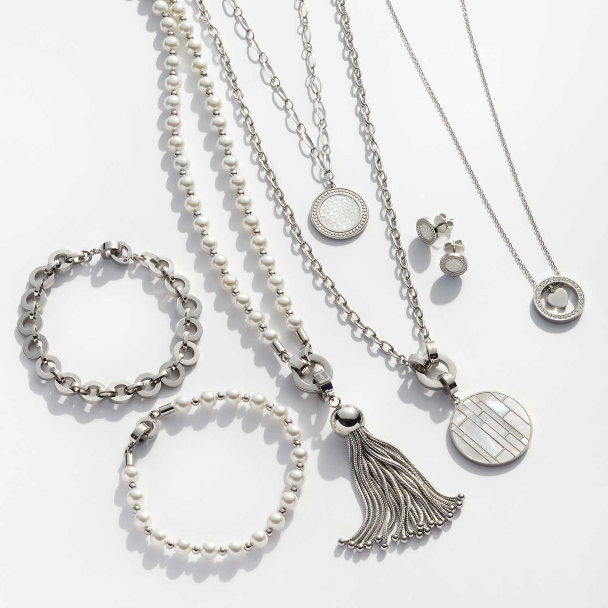 Silberschmuck-Kollektion mit Armbändern, Ketten und Ohrringen auf weißem Hintergrund