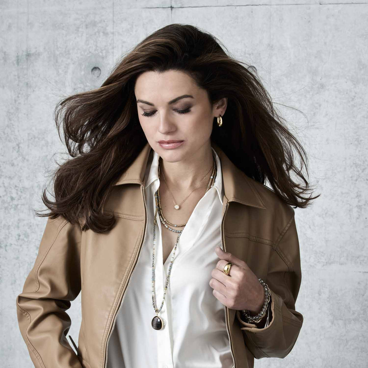 Frau trägt Creole ELODIE gold mit weißer Bluse und beigem Blazer