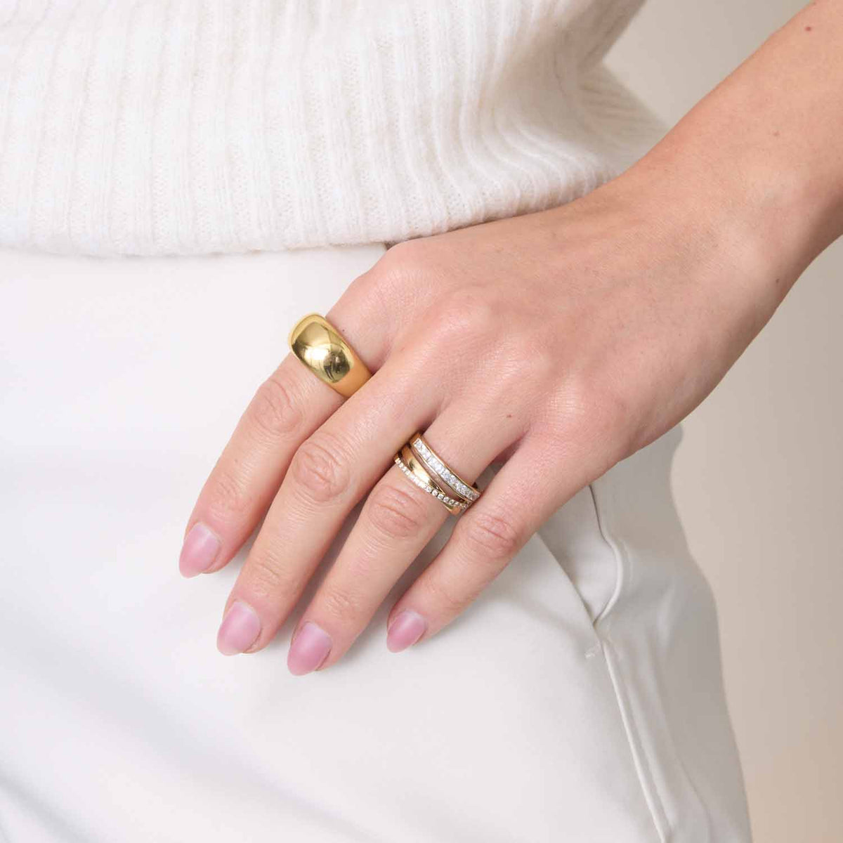 Hand mit Ring GEORGETTE 18 gold, weiße Kleidung, rosafarbene Nägel