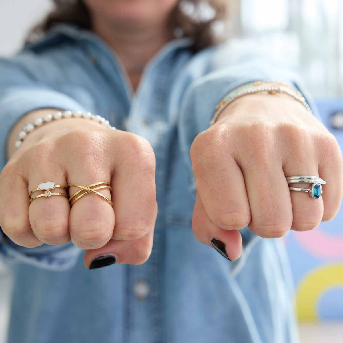 Frau mit geballten Fäusten trägt silberne Ringe an Fingern