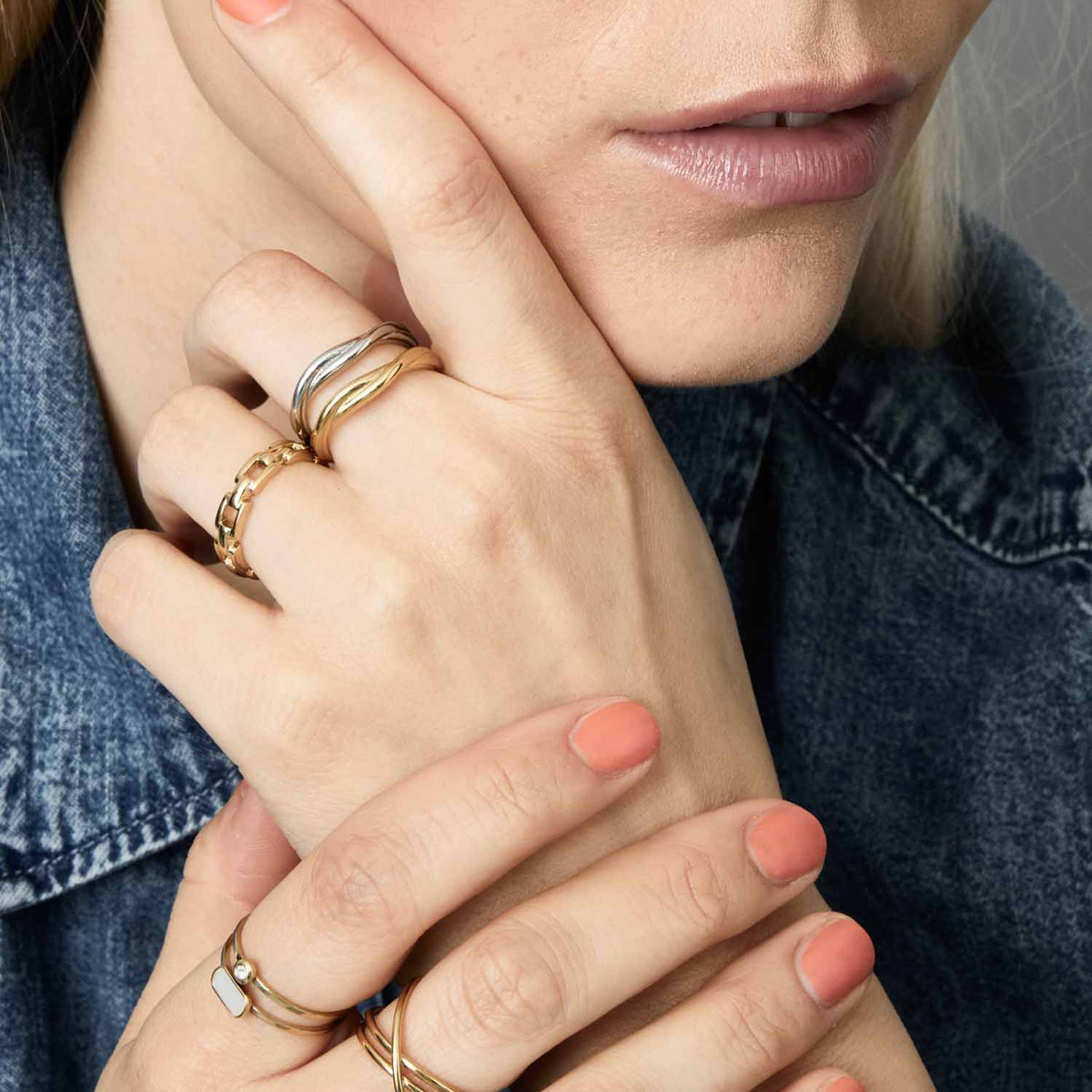 Frau traegt Ring TWISTER 19 gold CIAO an der Hand, weitere goldfarbene Ringe sichtbar