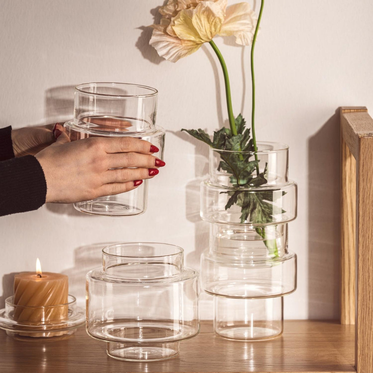 Dose PER TUTTO in Wohnraum mit Blume, Kerze und Hand mit rotem Nagellack