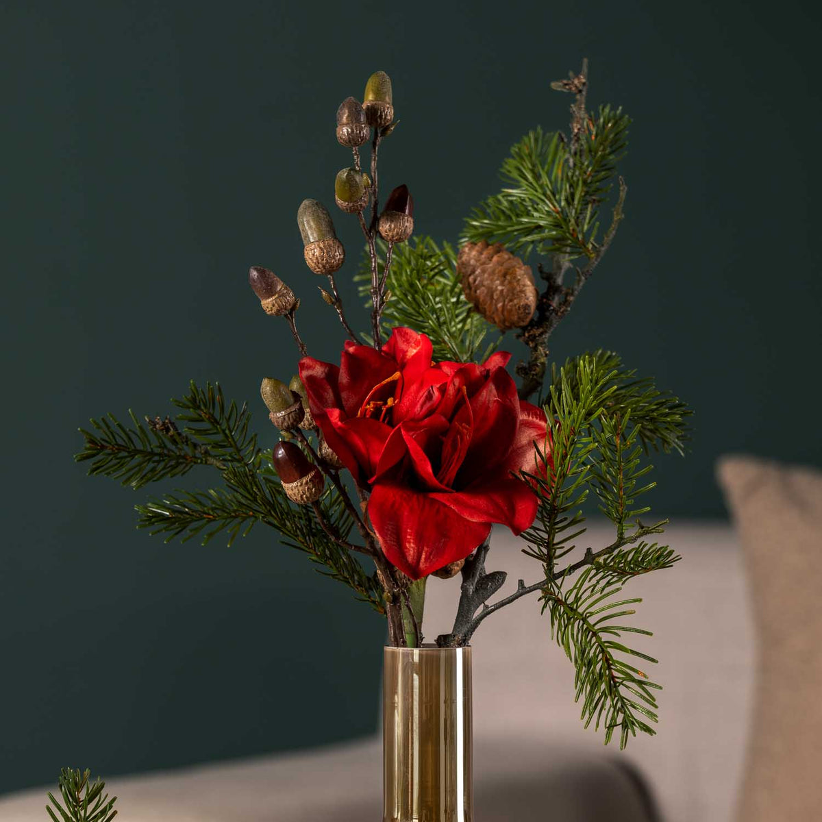 Rote Amaryllis in Glasvase vor grauem Hintergrund mit Grünwerk