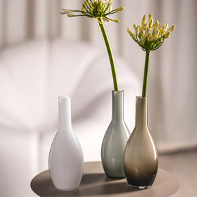Drei Vasen mit Blüten in heller Raumumgebung, grau gefärbte Vase BEAUTY in der Mitte