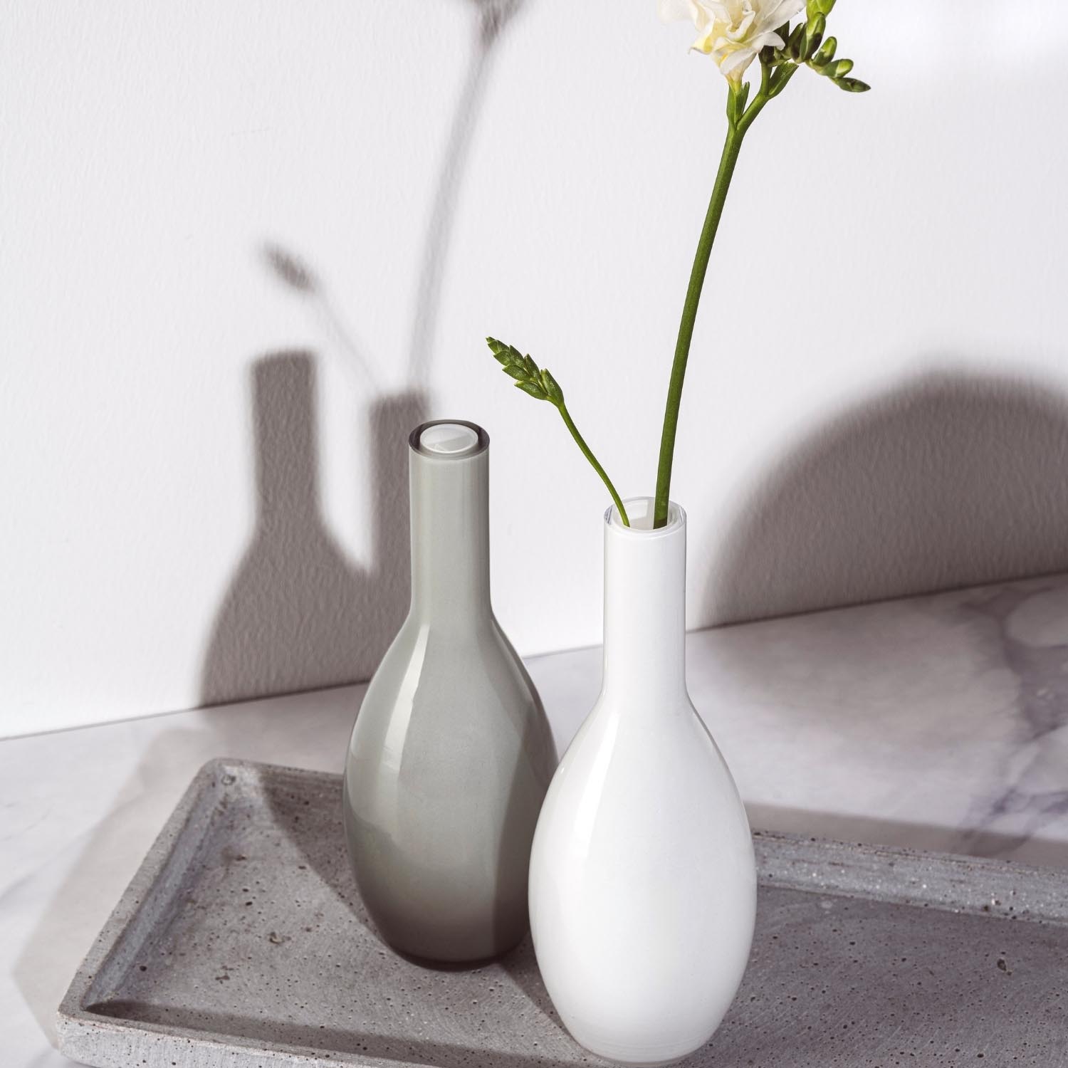 Vase BEAUTY 18 cm grau neben weißer Vase mit Blumen auf Betonablage