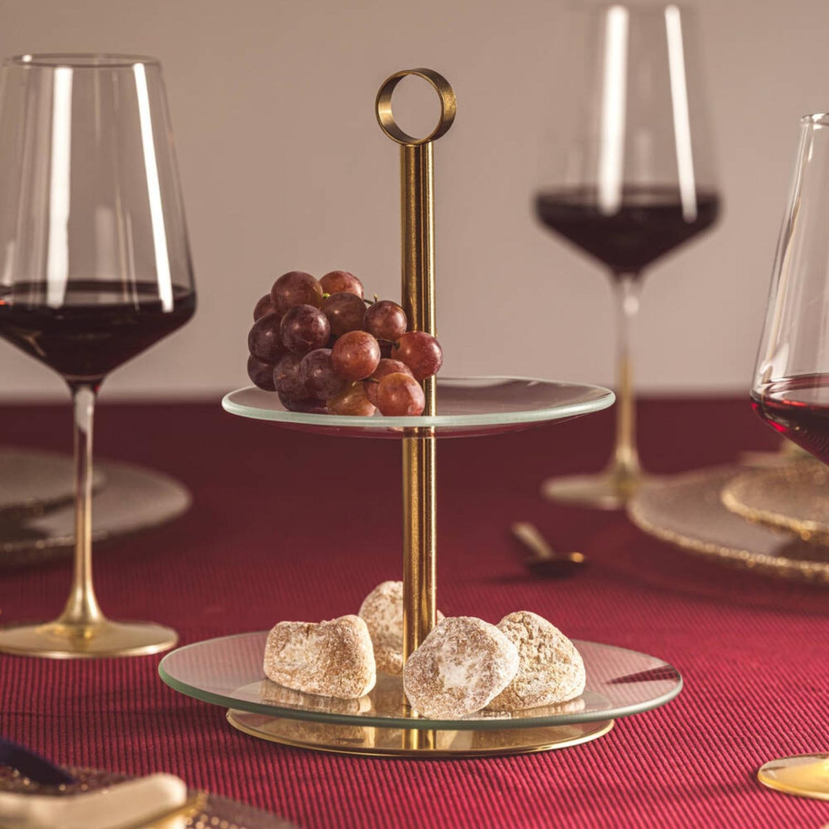 Etagere CENA gold 2-teilig mit Trauben und Gebäck auf gedecktem Tisch