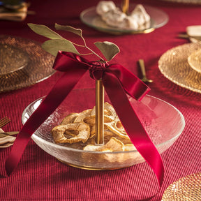 Schale CENA 25 cm gold auf gedecktem Tisch mit Besteck und roter Schleife