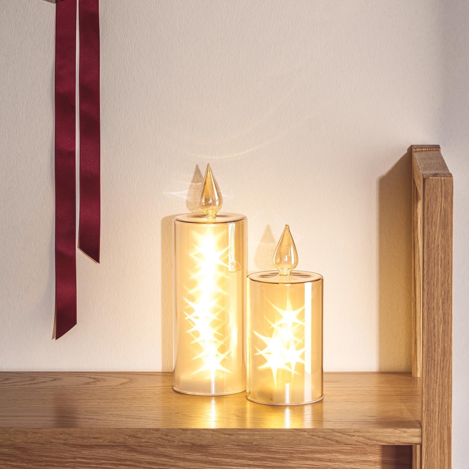 LED Kerze RIPOSO in Gold auf Holzregal neben Holzbox, mit Dekoration