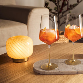 LED Lampe RIPOSO auf Holztisch neben zwei Cocktailgläsern und Vase