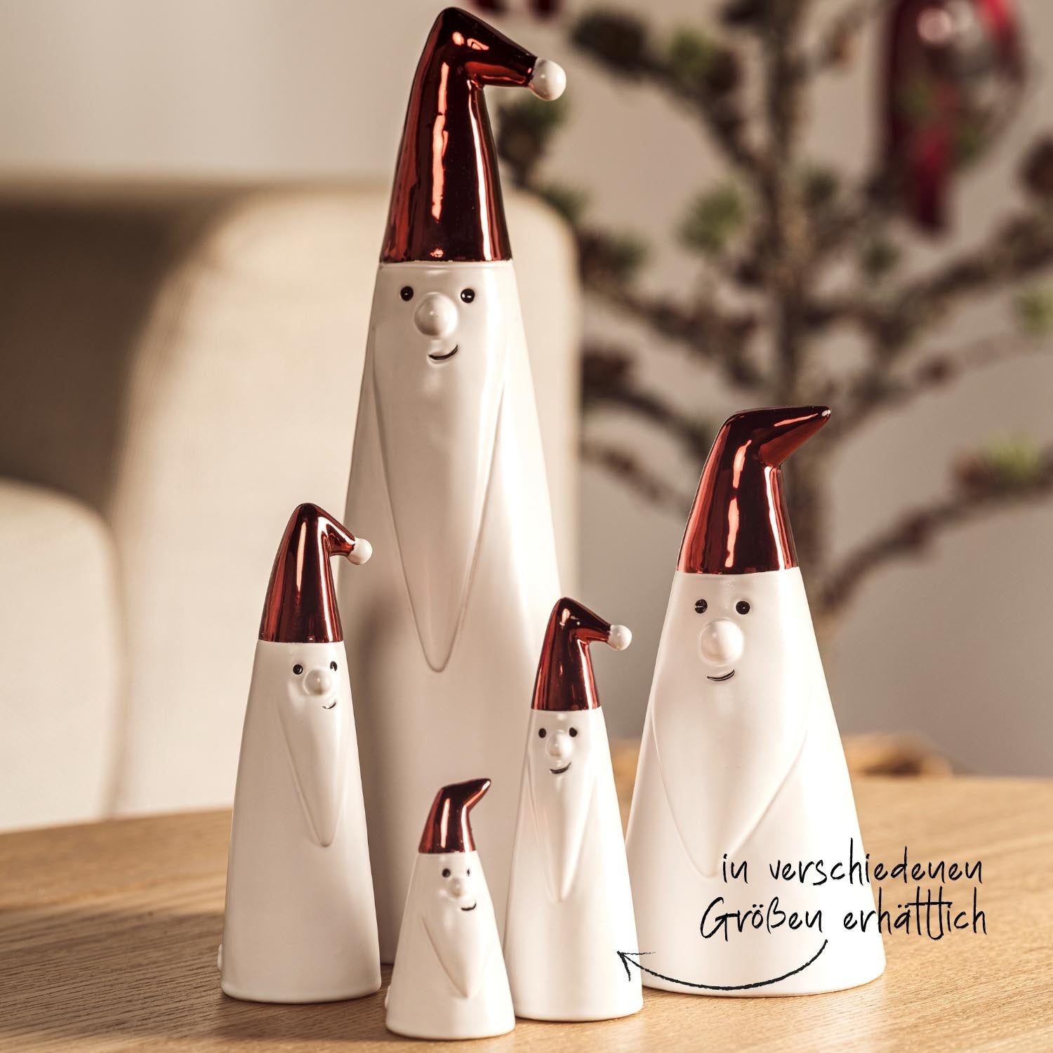 Weihnachtsmänner GIANNI in verschiedenen Größen mit roten Mützen auf Holztisch
