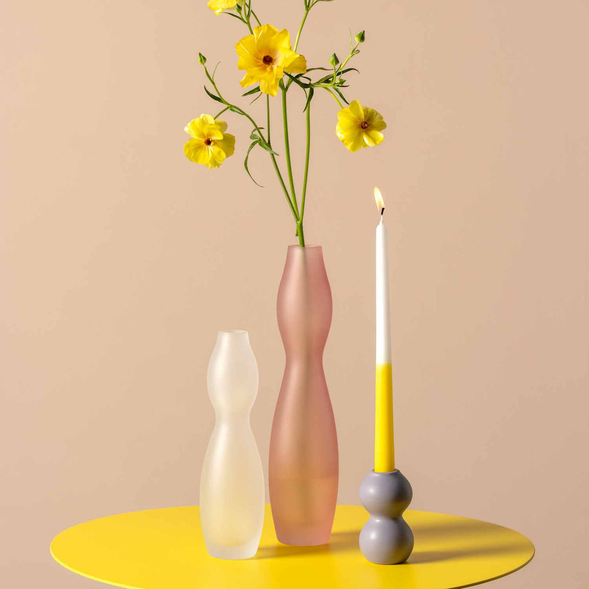 Vase VIVACE 25 cm satiniert mit gelben Blumen auf gelbem Tisch, Kerze daneben