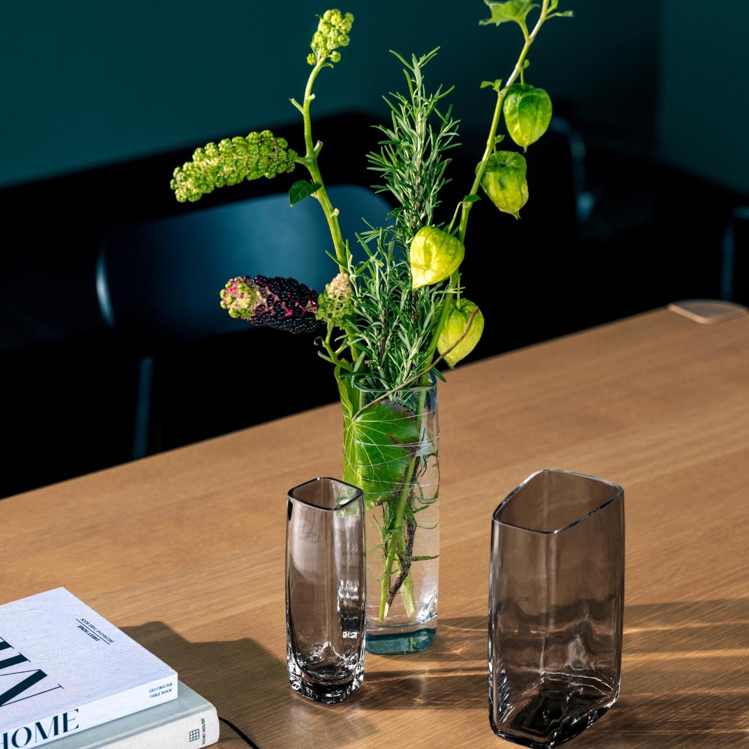 Solifleurvase PIETRA mit grünen Pflanzen auf Holztisch neben Magazinen