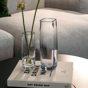 Solifleurvase PIETRA mit Blumenstiel auf Buch in Wohnzimmeratmosphäre