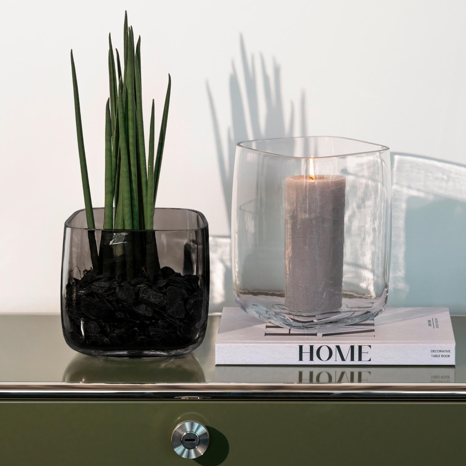 Vase PIETRA grau mit Kerze und grüner Pflanze auf grünem Sideboard, Wohnraum-Styling