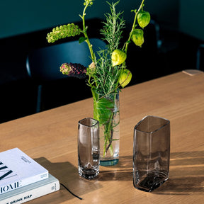 Vase PIETRA 20 cm schmal grau mit grünen Pflanzen und gelben Blüten auf Holztisch