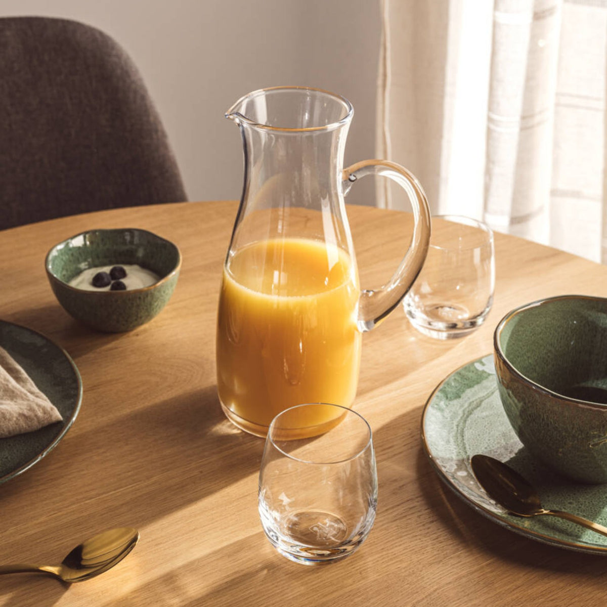 Krug PIENO 1,5 l mit Orangensaft gefüllt auf gedecktem Esstisch