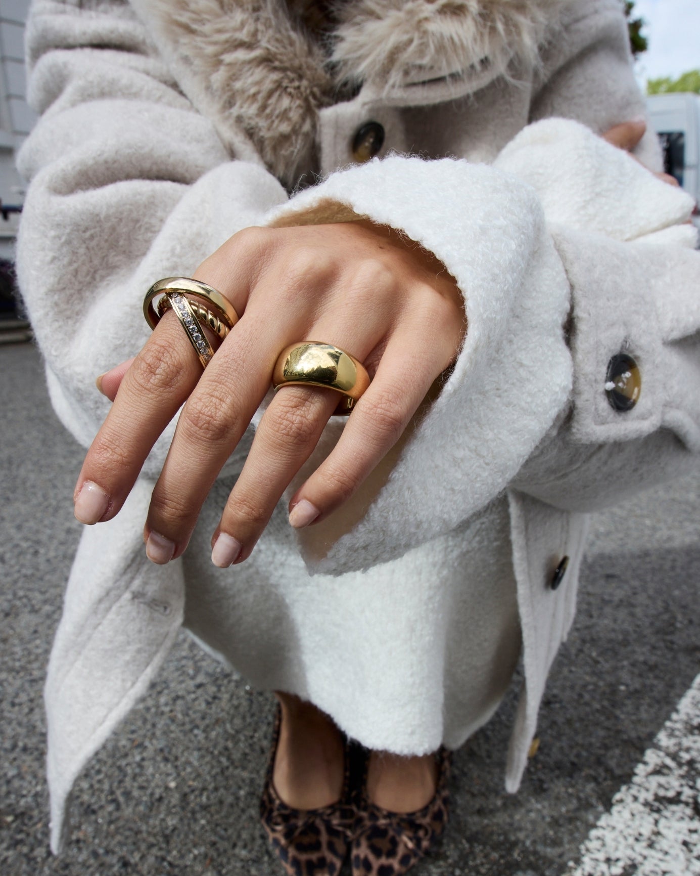Frau in weißem Wollpullover trägt goldene Ringe an den Händen, elegante Herbst-Winter-Kollektion