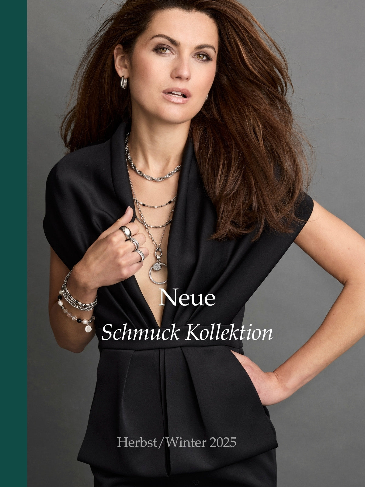 Model mit braunen Haaren und schwarzem Outfit trägt auffälligen Schmuck aus der neuen Herbst/Winter-Kollektion 2025 – Fokus auf Ketten, Ringe und Armbänder. Mit der Aufschrift "Neue Schmuck Kollektion Herbst/ Winter 2025".