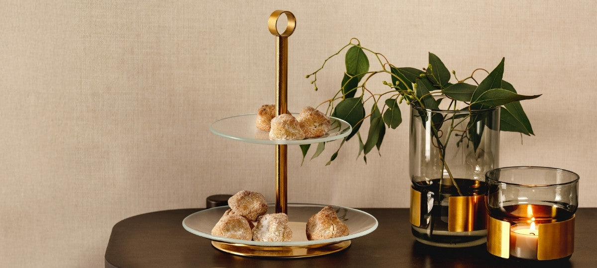 Weihnachtlicher Banner mit goldener Etagere, festlichem Gebäck und dekorativen Kerzen- und Glasakzenten von LEONARDO.